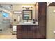 Bathroom featuring granite countertop, wooden cabinets, and tiled shower with glass door at 2140 Torrey Pine Dr, Evergreen, CO 80439