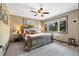 Bedroom featuring a rustic wooden bed frame, ceiling fan, and bright windows at 2140 Torrey Pine Dr, Evergreen, CO 80439