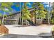 Inviting exterior featuring stone accents, mature trees, a spacious driveway, and an attached two car garage at 2140 Torrey Pine Dr, Evergreen, CO 80439
