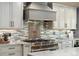 Beautiful kitchen with stainless steel appliances, custom backsplash, and a high-end stove with a hood at 2140 Torrey Pine Dr, Evergreen, CO 80439