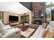 Spacious living room boasts a stone fireplace, hardwood floors, and access to the outdoor deck at 2140 Torrey Pine Dr, Evergreen, CO 80439