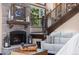 Cozy living room features a stone fireplace, wood mantel, and stairway to upper level at 2140 Torrey Pine Dr, Evergreen, CO 80439