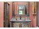 Rustic powder room features a wood vanity, copper sink, and decorative mirror at 2140 Torrey Pine Dr, Evergreen, CO 80439