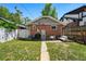 Brick home backyard with lush lawn, patio seating, and privacy fence at 3437 W 35Th Ave, Denver, CO 80211