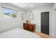 Cozy bedroom features wood floors, a dresser, and a black paneled door at 3437 W 35Th Ave, Denver, CO 80211