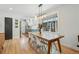 Bright dining room featuring a wooden table, modern lighting fixture, and view of a brick structure from a large window at 3437 W 35Th Ave, Denver, CO 80211