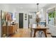 Dining area showcasing a wooden table, hardwood floors, and a view into the modern kitchen at 3437 W 35Th Ave, Denver, CO 80211