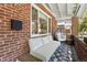 Inviting front porch with brick detail, hanging chair, and comfortable seating area at 3437 W 35Th Ave, Denver, CO 80211