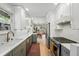 Open kitchen leading to the dining area and living room, stainless steel appliances, and wood flooring at 3437 W 35Th Ave, Denver, CO 80211