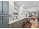 Bright kitchen featuring white cabinets, quartz countertops, and stainless steel appliances open to the dining room at 3437 W 35Th Ave, Denver, CO 80211