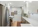 Modern kitchen featuring white cabinets, stainless steel appliances, and hardwood flooring at 3437 W 35Th Ave, Denver, CO 80211