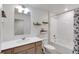 Well-lit bathroom with modern vanity, white tile shower-tub, and stylish shelving at 1800 Vantage Pkwy, Berthoud, CO 80513