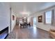 Open-concept living room with fireplace, dining area, kitchen, and natural light at 1800 Vantage Pkwy, Berthoud, CO 80513