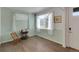 Cozy room featuring pale-green walls, hardwood floors, bright windows with sheer curtains and a vintage table at 1800 Vantage Pkwy, Berthoud, CO 80513