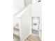 Carpeted staircase with white walls leads to a bright foyer; wreath on door at 1800 Vantage Pkwy, Berthoud, CO 80513