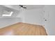 Upstairs bedroom with hardwood floors, white walls, ceiling fan, and natural lighting from skylight at 17003 E Tennessee Dr # 209, Aurora, CO 80017