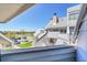 View of the townhome exterior from the balcony with partial views of parking and green space at 17003 E Tennessee Dr # 209, Aurora, CO 80017