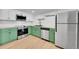 Well-lit kitchen featuring stainless steel appliances, subway tile backsplash, and green lower cabinets at 17003 E Tennessee Dr # 209, Aurora, CO 80017