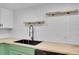 Close-up of kitchen sink with wood counter tops, subway tile backsplash, and industrial faucet at 17003 E Tennessee Dr # 209, Aurora, CO 80017