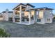 Back of a two-story house featuring a stone chimney and lots of windows at 19647 Guildford Ct, Monument, CO 80132