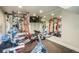 Well-equipped home gym featuring weightlifting machines, exercise bike, mirrored wall and wall mounted tv at 19647 Guildford Ct, Monument, CO 80132