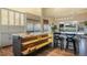 Modern kitchen featuring an island with wooden shelving, stylish stools, and marble countertops at 19647 Guildford Ct, Monument, CO 80132