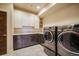 Bright laundry room featuring modern appliances and plenty of counter space at 19647 Guildford Ct, Monument, CO 80132