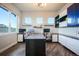 Home office with built-in shelving and cabinets, three windows, and wood floors at 19647 Guildford Ct, Monument, CO 80132