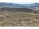 Aerial view of undeveloped land showing rolling hills and distant mountains at 8501 Hackamore Rd, Littleton, CO 80125