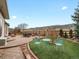Inviting backyard with a stone patio, green lawn, mountain views, and a tranquil seating area for outdoor relaxation at 8501 Hackamore Rd, Littleton, CO 80125
