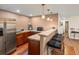 Finished basement bar area with barstool seating, wood flooring, cabinets, and stainless steel refrigerator at 8501 Hackamore Rd, Littleton, CO 80125