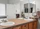 Bathroom with double sink vanity, tile countertop, and a large mirror at 8501 Hackamore Rd, Littleton, CO 80125