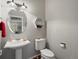 Charming powder room with pedestal sink, round mirror, and modern fixtures at 8501 Hackamore Rd, Littleton, CO 80125