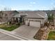 Suburban home with a three-car garage, manicured lawn, garden feature, and mountain views at 8501 Hackamore Rd, Littleton, CO 80125