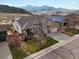 Aerial view of a suburban home with mountain views, solar panels, and a well-maintained lawn and garden at 8501 Hackamore Rd, Littleton, CO 80125