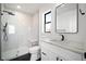Modern bathroom featuring a stand-up shower with white marble and black fixtures, plus a sleek vanity with stone counter at 4647 Bryant St, Denver, CO 80211