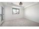 Bright bedroom with neutral carpeting, a large window, and a modern ceiling fan, offering a serene space at 4647 Bryant St, Denver, CO 80211