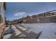 Snowy backyard with patio and retaining wall at 15726 E Otero Cir, Centennial, CO 80112