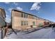 Rear view of two-story house with patio and snow at 15726 E Otero Cir, Centennial, CO 80112