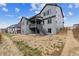 Exterior view of a gray two-story home and backyard with a stairway leading to a deck at 1825 Morgan Dr, Erie, CO 80516