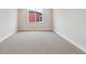 Empty bedroom featuring neutral carpet, base trim, and single window at 1825 Morgan Dr, Erie, CO 80516