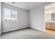 Vacant bedroom with neutral carpet, base trim and view to the bathroom at 1825 Morgan Dr, Erie, CO 80516