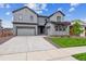 Modern two-story home with gray siding, attached garages, and well-maintained lawn at 1825 Morgan Dr, Erie, CO 80516