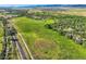 An aerial view of a vast green field with a home nestled among trees, creating a picturesque and private landscape at 11475 Us Highway 85, Littleton, CO 80125