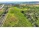 An aerial view of a vast green field with a home nestled among trees, creating a picturesque and private landscape at 11475 Us Highway 85, Littleton, CO 80125