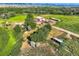 Scenic aerial perspective of sprawling land with mature trees, barns, sheds and a charming residential dwelling at 11475 Us Highway 85, Littleton, CO 80125