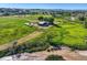 Aerial perspective highlighting an expansive rural property with barns, outbuildings, a winding river, and lush fields at 11475 Us Highway 85, Littleton, CO 80125