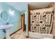 Bathroom with a pedestal sink, patterned shower curtain, and ceramic tile at 11475 Us Highway 85, Littleton, CO 80125
