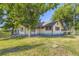 Side view of a quaint home surrounded by lush green grass and mature trees, exuding a peaceful atmosphere at 11475 Us Highway 85, Littleton, CO 80125