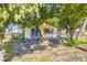 Charming home exterior with a sliding glass door, stone walkway, and mature shade trees at 11475 Us Highway 85, Littleton, CO 80125